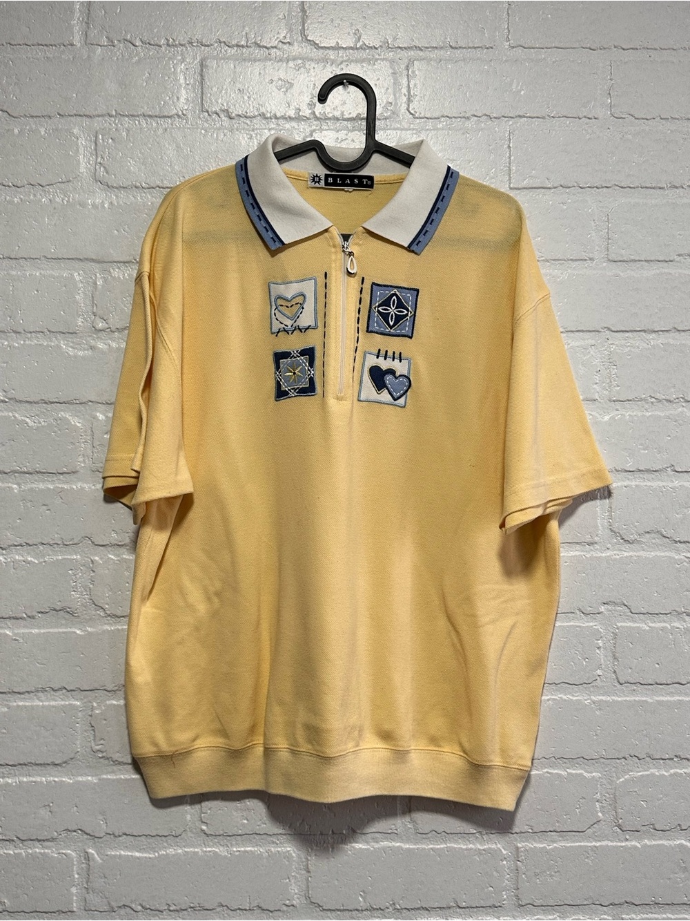 Yellow polo shirt with blue accents and embroidered details
